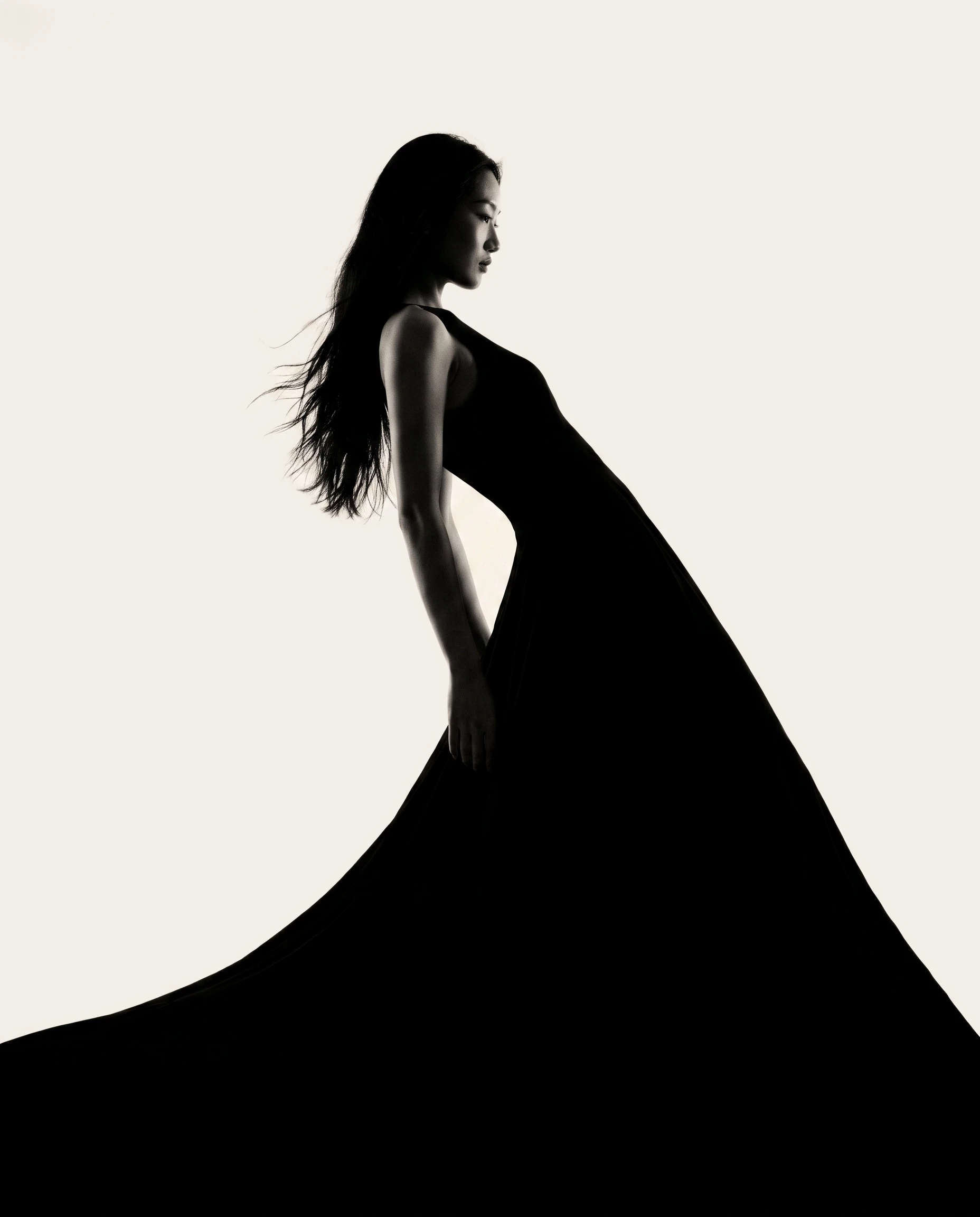 Femme en grande robe noire, cheveux dans le vent
